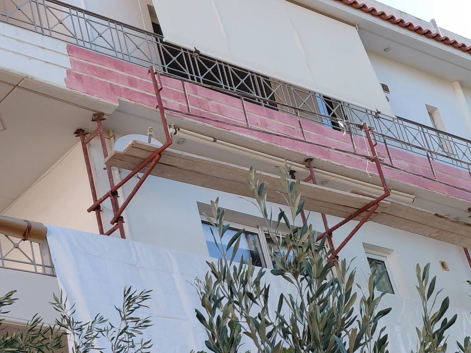 Όψη με σκαλωσιά και εμφανείς στρώσεις θερμοπρόσοψης.