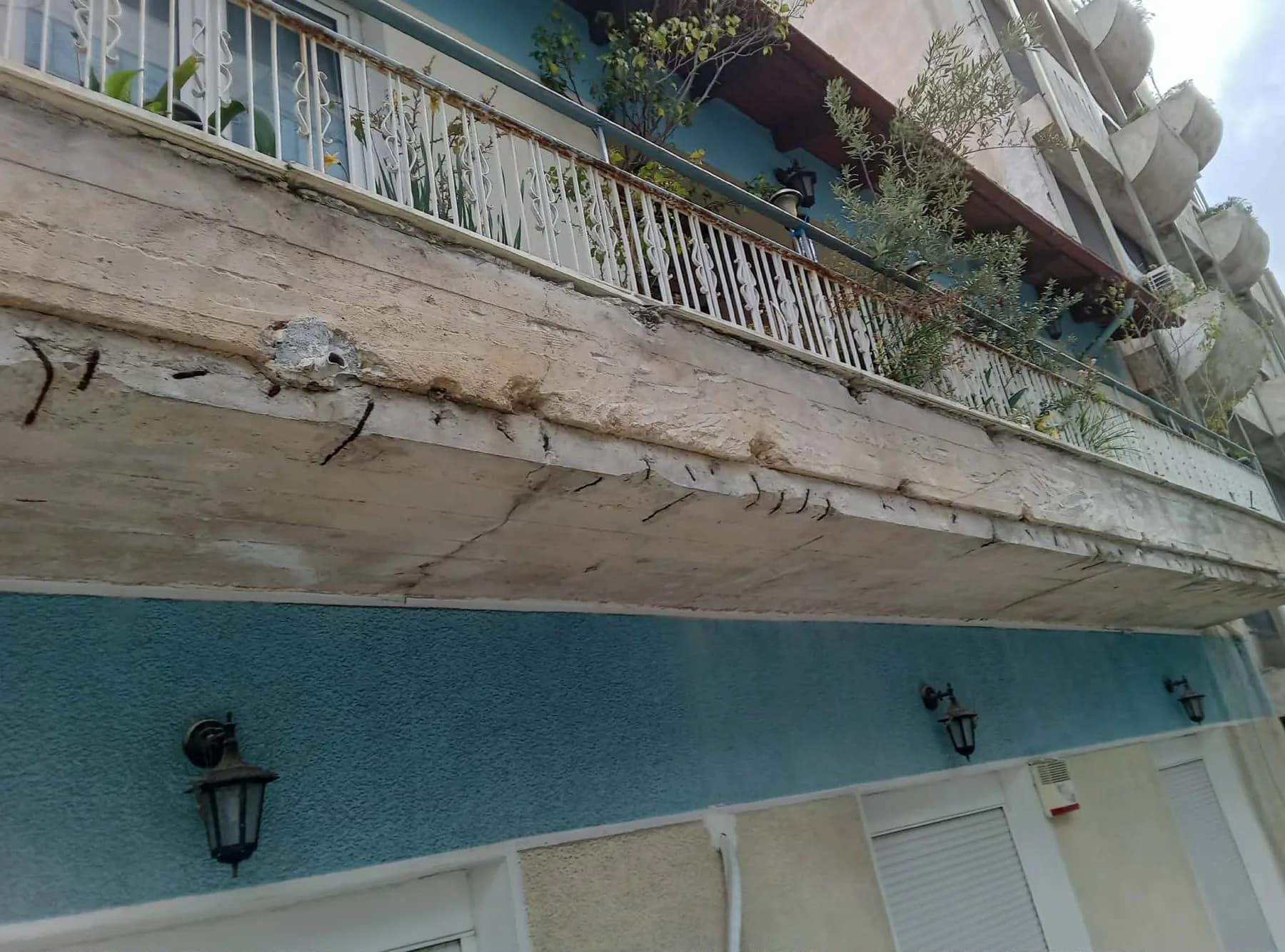 Εκτεταμένα σαθρά μπετά στην κάτω όψη μπαλκονιού πριν από την αποκατάσταση.
