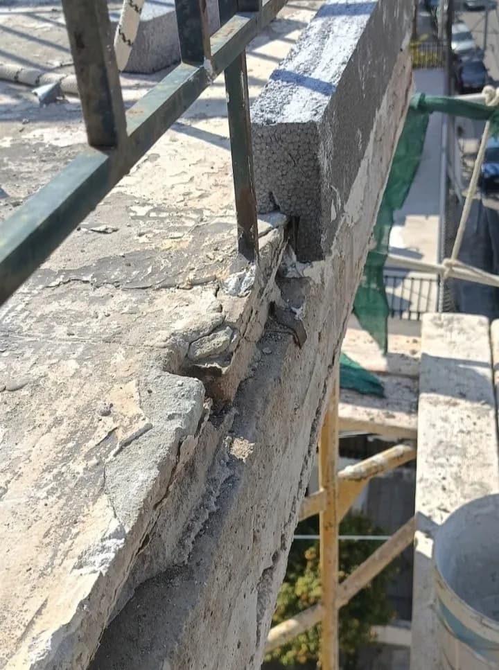 Κοντινή λήψη φθοράς σε μετώπη και ακμή μπαλκονιού πριν από επισκευή.